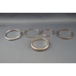 Five various silver or white metal bangles