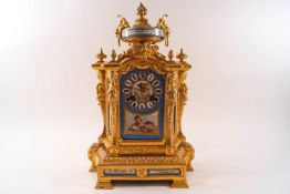A 19th century French gilt metal clock inset with porcelain panels bearing cherub and flower