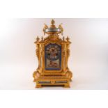 A 19th century French gilt metal clock inset with porcelain panels bearing cherub and flower