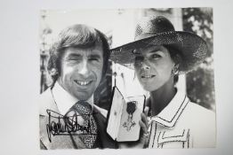 A signed photograph of Jackie Stewart receiving his OBE,