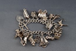 A silver curb link charm bracelet on a padlock clasp, Birmingham 1965,