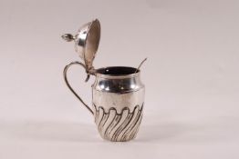 A Victorian silver barrel shaped small mustard pot, part spiral fluted, with a scroll handle,