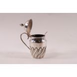 A Victorian silver barrel shaped small mustard pot, part spiral fluted, with a scroll handle,