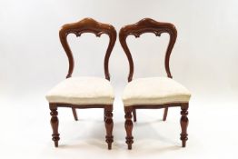 A pair of Victorian style mahogany dining chairs with over stuffed seats