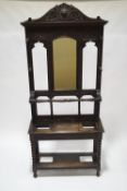 A Victorian carved oak hall stand with mirrored back, carved decoration and bobbin turned supports,