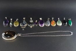 A miscellaneous collection of white metal and gem set pendants