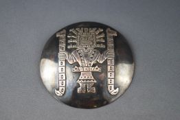 A Peruvian round pendant decorated in Aztec style, stamped with a llama, and 'Chavez-Peru, 925', 6.