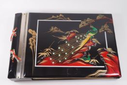A Japanese lacquered musical photograph album, the cover with peacock decoration,