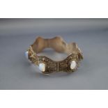 An eastern white metal and oval translucent glass bracelet,