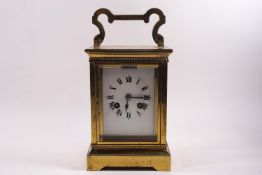 A large brass carriage clock, eight day movement, striking on a gong, with winding key, 26cm high,