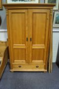 A Victorian pine double wardrobe with hanging rails and single drawer to base,