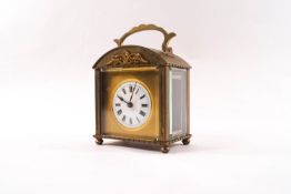 An Empire style brass carriage clock with domed top and gilt metal mount, 12.