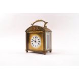 An Empire style brass carriage clock with domed top and gilt metal mount, 12.