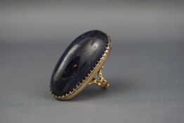 A large blue stone single stone ring possibly tanzanite, the high-dome oval cabochon approx.
