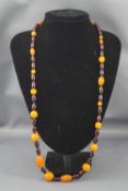 An imitation red amber and orange plastic bead necklace, approx. 78cm long overall.