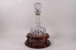 A 20th century cut glass decanter and stopper, with spherical body and silver collar,