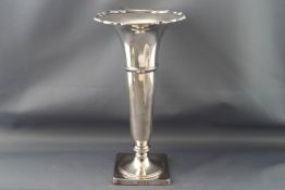 A silver flared vase on a loaded square foot, Birmingham 1930, 21.