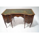 An Edwardian mahogany lady's writing desk with green leather inset top over an arrangement of seven