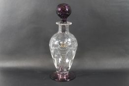 A Webbs amethyst and clear glass footed decanter and globular stopper, with crescent pattern within,