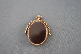 A late Victorian 9ct rose gold, bloodstone and cornelian spinning fob with a curb link surmount,