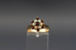 A 9ct gold, garnet and white opal cluster ring, post 2000 London convention marks, size O, 2.