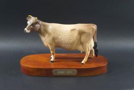 A Beswick figure of 'Jersey Cow' on a wooden plinth