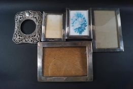 Four silver photograph frames each of plain form, the largest overall 17cm x 12.