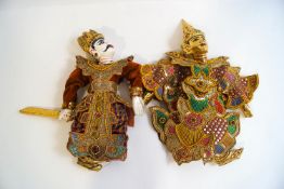 A pair of Thai wooden puppets, painted with gold and ornately costumed with beading and sequins,