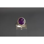 An 18ct white gold, amethyst and diamond oval cluster ring,