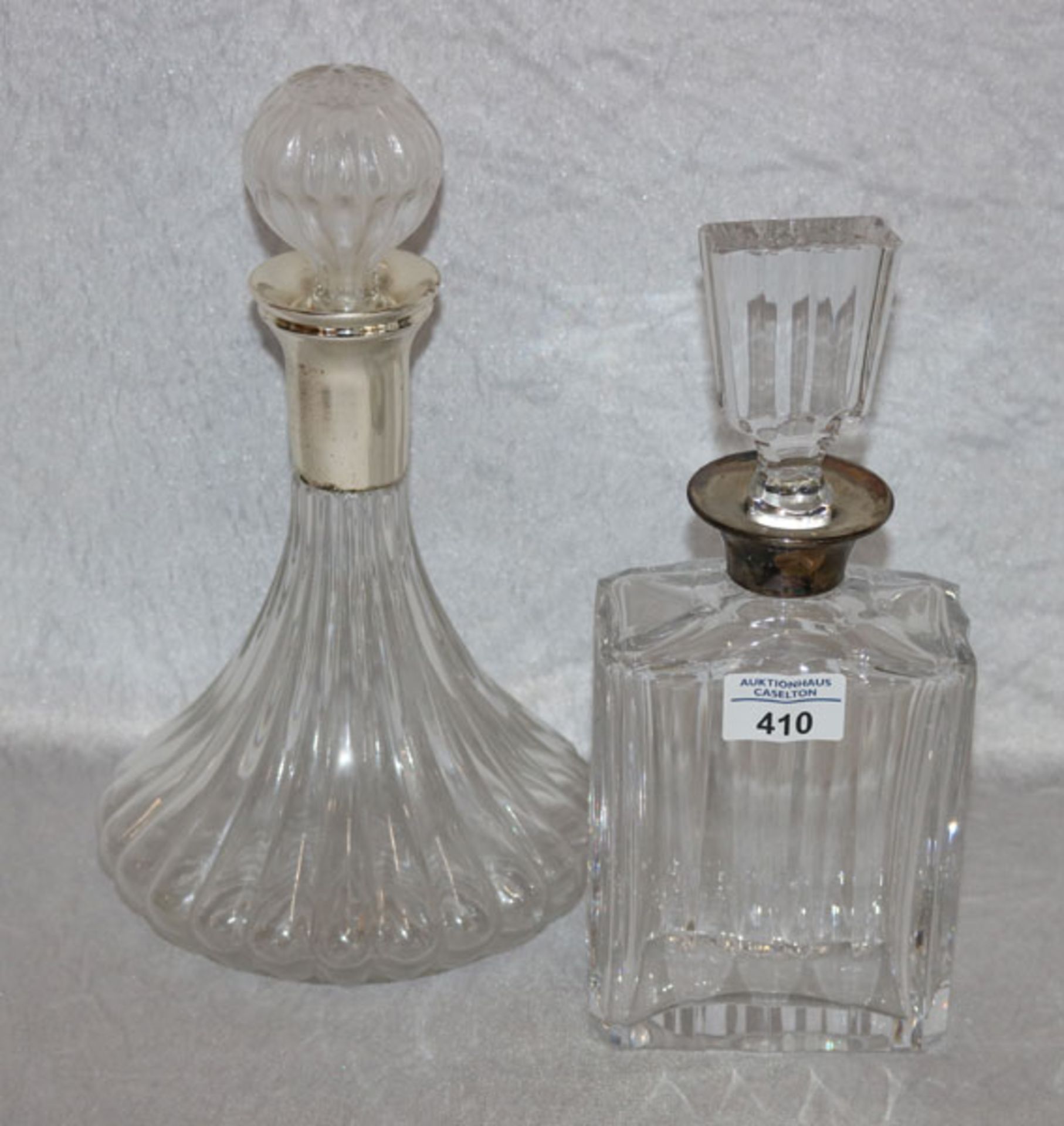 Glas Karaffe mit Silberhals, H 28 cm, B 12 cm, T 7 cm, und Glas Karaffe mit versilbertem Hals, H
