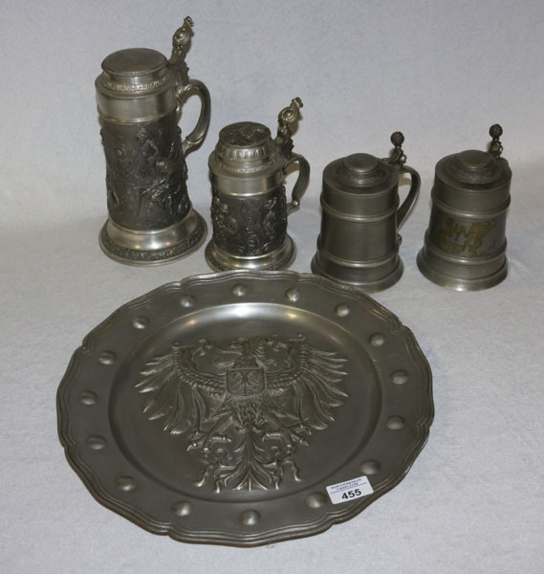 Großer Zinnteller mit reliefiertem Wappendekor, D 38 cm, 4 Zinnkruge mit Deckel, H 17/27 cm,