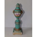 A Berlin porcelain turquoise glazed pedestal urn with cover, decorated with two small panels