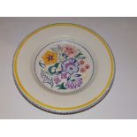 A Poole painted plate decorated flowers..