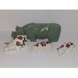 A Bovey Pottery celadon rhino, 9.5” across, a small Plichta pig and two sleeping dogs. (4)