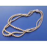 An imitation pearl triple strand necklace with marcasite clasp.