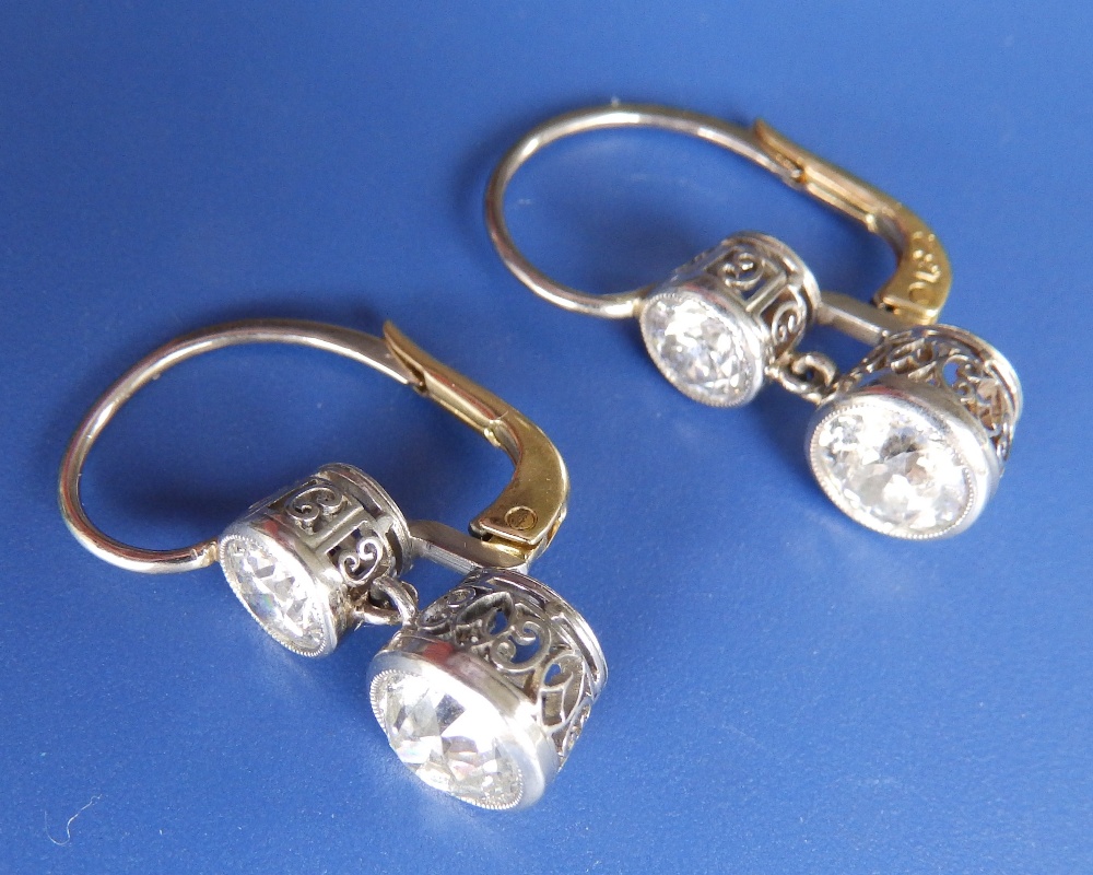 A pair of two stone diamond drop earrings, the two principle old cut stones of combined total weight