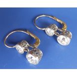 A pair of two stone diamond drop earrings, the two principle old cut stones of combined total weight