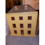 A yellow painted modern wooden doll's house with contents, having hipped roof with two dormer