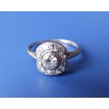 An art deco diamond set white metal panel cluster ring, the central brilliant weighing approximately
