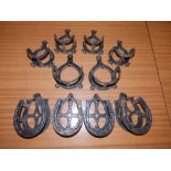 Ten horse shoe shaped iron wall hangers.