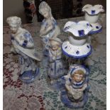 A pair of continental figural porcelain candlesticks and three others. (5)