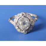 An oval diamond millegrain set open cluster ring, the central old cut stone weighing 1.10 carats –