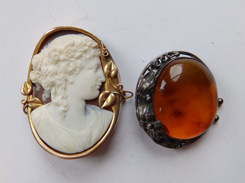 A cameo brooch and an art nouveau amber brooch. (2)