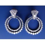 A pair of diamond set white metal hoop earrings, each formed as two concentric circles set with