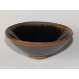 A small Chinese Song Dynasty stoneware bowl glazed in black with brown rim, 3.5” diameter.