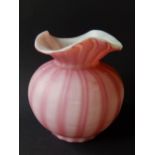 A pink overlaid striped glass vase with trefoil rim, 4.5” high.