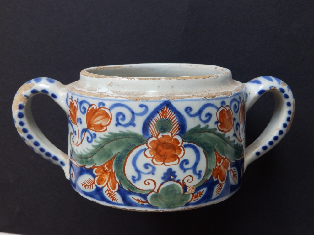 An 18thC two-handled faience jar, decorated flowers and arabesque scrolls in iron red, green & blue,