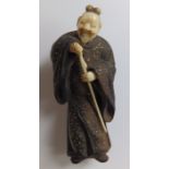 A 19thC Japanese wood & ivory netsuke figure of a sage holding a staff, gold painted details to