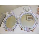 A pair of 19thC Dresden style porcelain strut mirrors – one cherub head restored, 12” high.