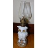 A 19thC Continental porcelain snowy owl oil lamp with glass eyes.